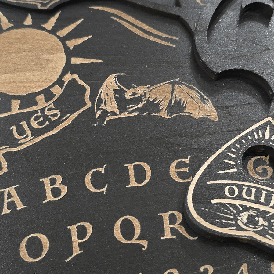 Unique black ouija board engraved and cut into wood. 