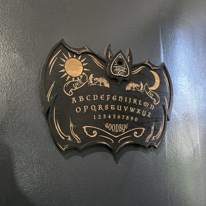 Unique black ouija board engraved and cut into wood. 