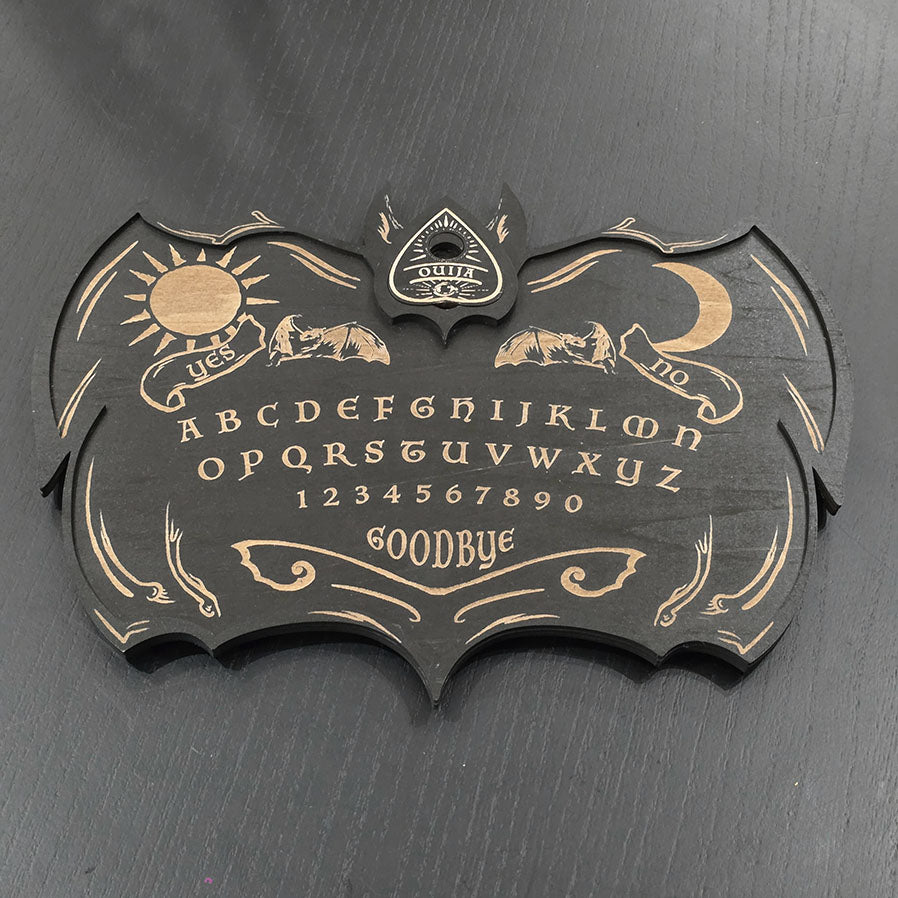 Unique black ouija board engraved and cut into wood. 