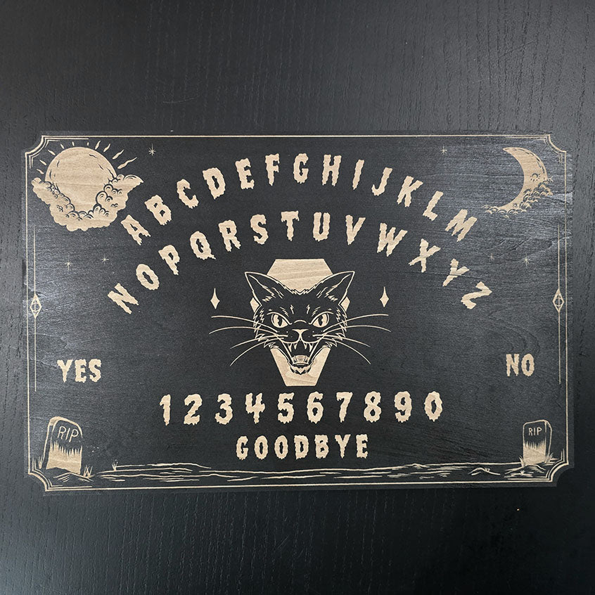 Ouija board with a black cat illustration on a dark background