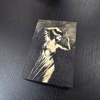 Black wooden box with bride of Frankenstein engraved on a dark surface