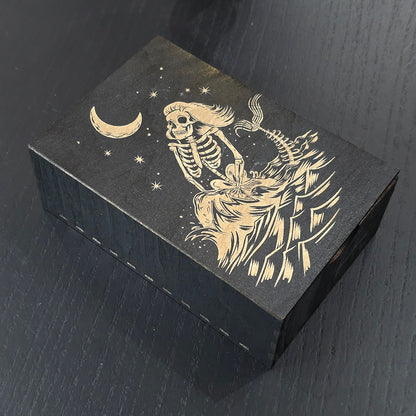 Black wooden box with a skeleton mermaid design engraved on a dark surface